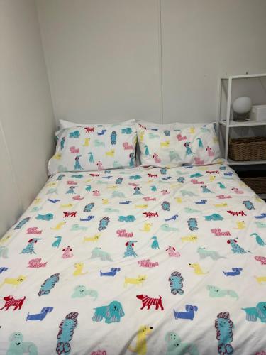 Una cama con un edredón con dinosaurios. en Baudin Beach Holiday Units, en Baudin Beach