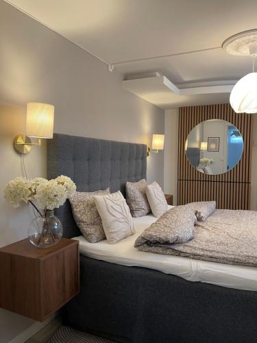 a bedroom with a large bed with a vase of flowers at Strömspärlan - Nordic Stay Strömstad in Strömstad