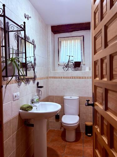 a bathroom with a white toilet and a sink at Casa Valdecid TU PAUSA RURAL in Valdeande