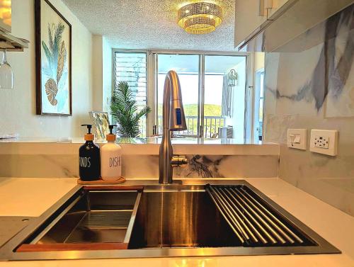 a kitchen counter with a sink and a window at Marina Views & Island Adventures: Fajardo Condo with Pool in Beltran