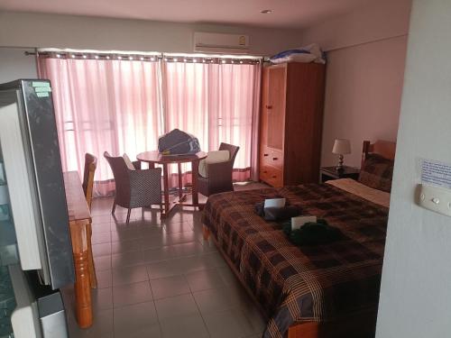 a bedroom with a bed and a table and chairs at VIP condochain 24th floor in Ban Phe