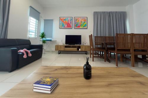 New Homestay Sandakan Rimbayu 12pax في سانداكان: غرفة معيشة بها أريكة وطاولة