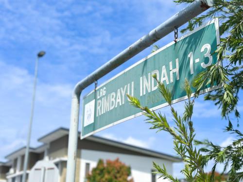 New Homestay Sandakan Rimbayu 12pax في سانداكان: وجود علامة على الشارع الأخضر أمام المبنى