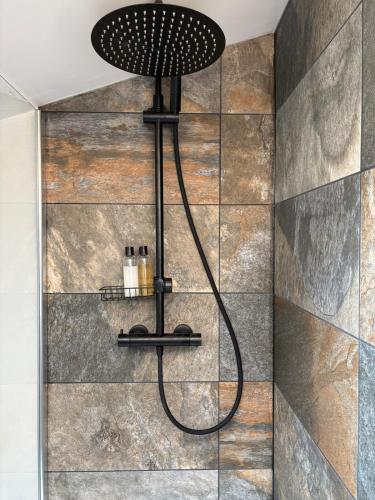 a shower with a black shower head in a bathroom at Duplex 6 pers 3 Ch, Billard & Netflix, tout équipé in Belleville-sur-Meuse