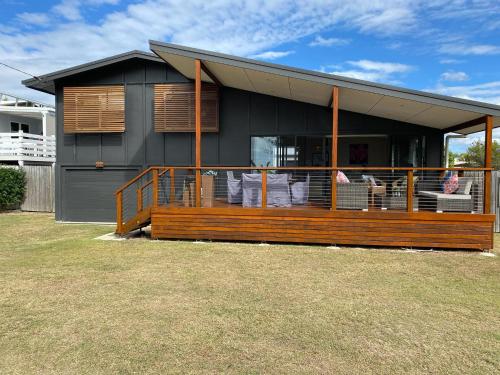 a house with a large deck with chairs on it at 58 The Esplanade in Woodgate
