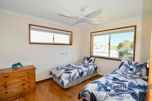 a bedroom with two beds and a ceiling fan at 25 The Esplanade in Woodgate