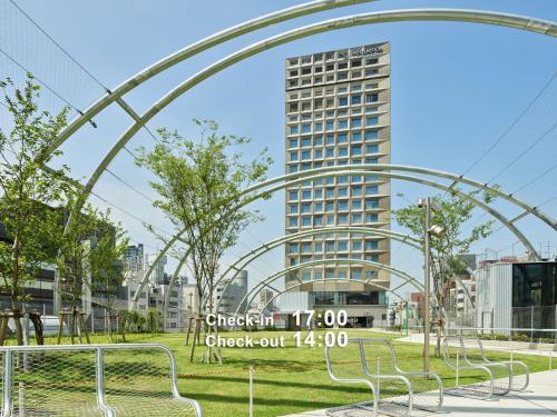 a group of benches in a park with a tall building at sequence MIYASHITA PARK - Shibuya in Tokyo