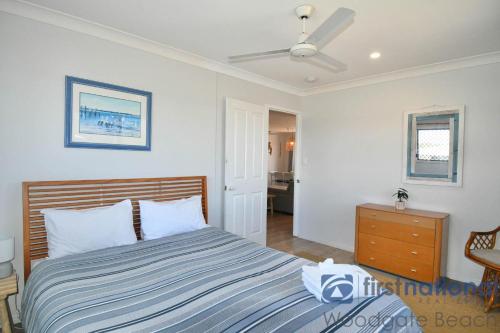 a bedroom with a bed and a ceiling fan at 50 The Esplanade in Woodgate