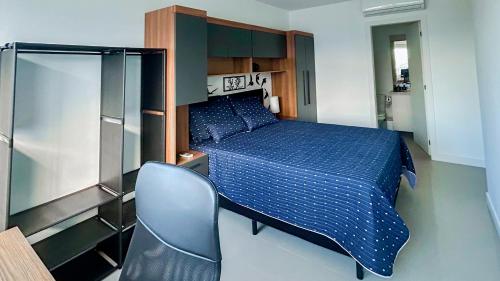 a bedroom with a blue bed and a chair at Condomínio próximo a ponte Hercílio Luz in Florianópolis