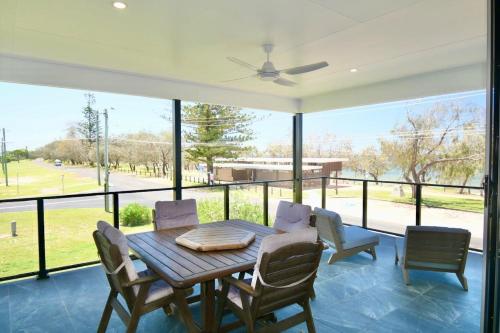 a dining room with a table and chairs and a large window at 158 The Esplanade in Woodgate