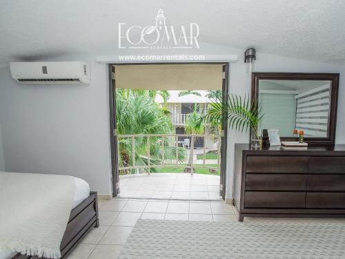 a bedroom with a bed and a dresser and a mirror at EcoMar Rentals: Villa in Cabo Rojo