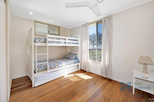a bedroom with bunk beds and a window at 185 The Esplanade in Woodgate