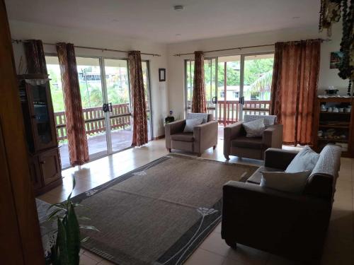 a living room with two couches and a rug at Sekoula Home in Suva