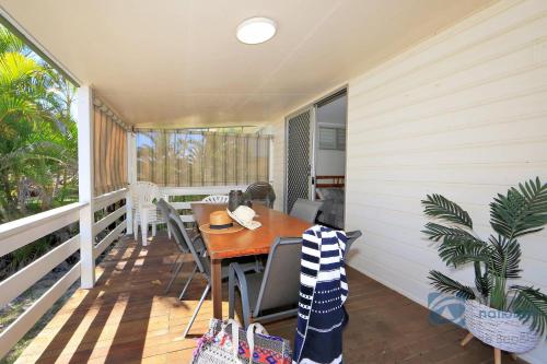 a porch with a table and chairs on a balcony at 185 The Esplanade in Woodgate