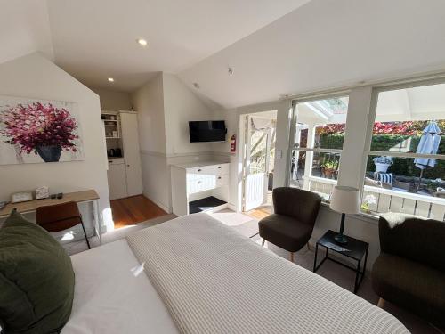 a living room with a bed and a couch and chairs at Arrowtown Lodge in Arrowtown