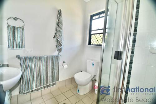 a bathroom with a toilet and a sink and a shower at 62 First Avenue in Woodgate
