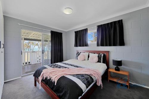 una camera da letto con un letto grande con cuscini rosa di 191 The Esplanade a Woodgate