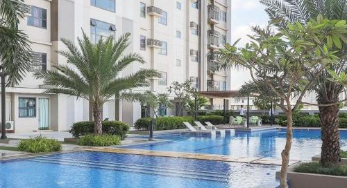 a swimming pool with palm trees in front of a building at Horizons 101 in Cebu City