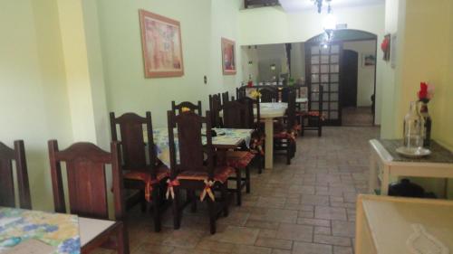 una sala da pranzo con molte sedie e un tavolo di Pousada Peruíbe Praia a Peruíbe