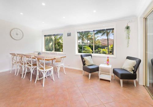 a dining room with a table and chairs at Coastal Palms - Family & Pet-Friendly Beachside Haven in Lake Illawarra