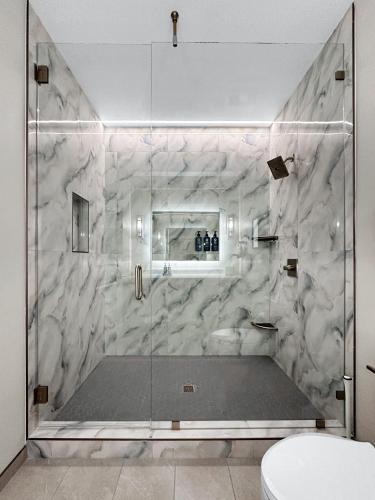 a bathroom with a glass shower with a toilet at Harbor Suites at Harborwalk Village in Destin