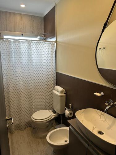 een badkamer met een toilet, een wastafel en een spiegel bij Modern apartment in Azul in Azul