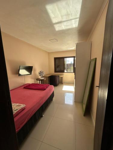 a bedroom with a bed with a red blanket at Casa perto do mar in Capão da Canoa