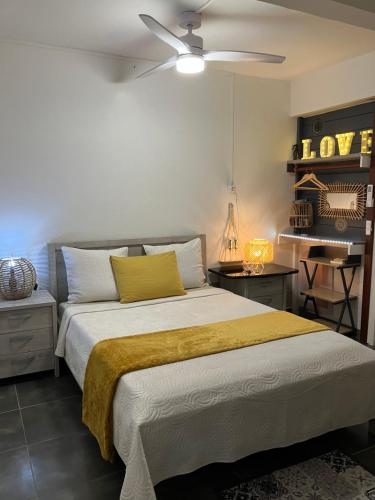 ein Schlafzimmer mit einem Bett mit einer gelben Decke darauf in der Unterkunft Tilys lodge in Capesterre-Belle-Eau