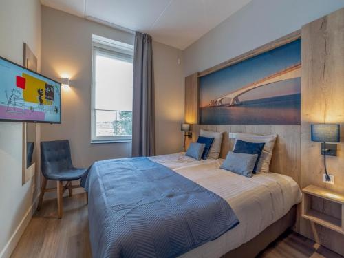 a bedroom with a large bed and a flat screen tv at SeaLuxe Suite 27D in Colijnsplaat