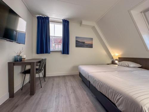 a bedroom with a bed and a desk and a table at Happy Beach 50 in Colijnsplaat