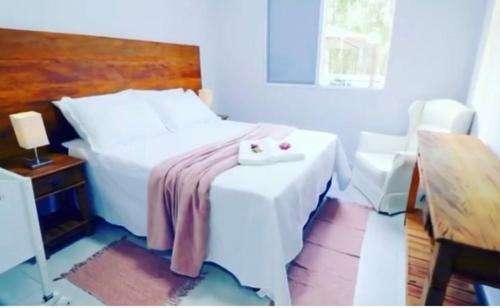 a bedroom with a white bed with two candles on it at Nano Resort in Porangaba