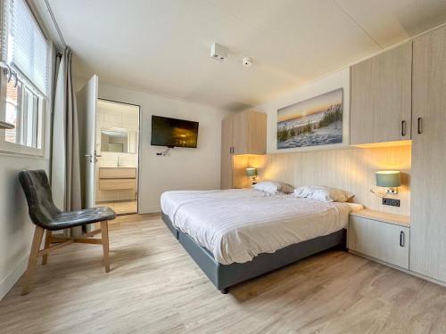 Un dormitorio con una cama, un escritorio y una silla. en Coast and Calm 63, en Colijnsplaat