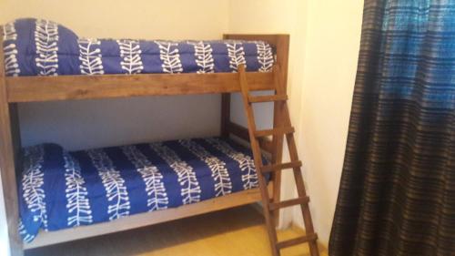 ein Etagenbett mit einer Leiter neben einem Vorhang in der Unterkunft Departamento Neuquen in Neuquén