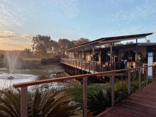 a restaurant on a dock next to a river at Serenity Diamond Beach in Diamond Beach