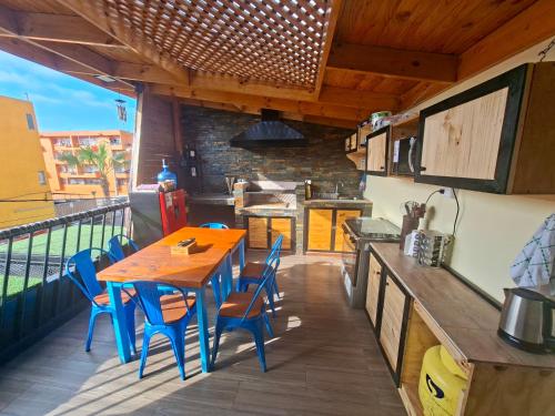 a kitchen with a wooden table and chairs on a balcony at Casona Eco Wing in Iquique
