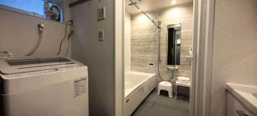 een badkamer met een bad, een wastafel en een toilet bij Kamakura Koshigoe Ekimae B in Kamakura