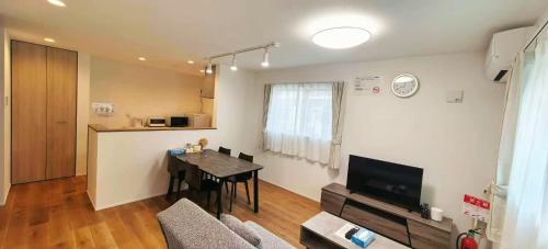 een woonkamer met een eettafel en een keuken bij Kamakura Koshigoe Ekimae B in Kamakura