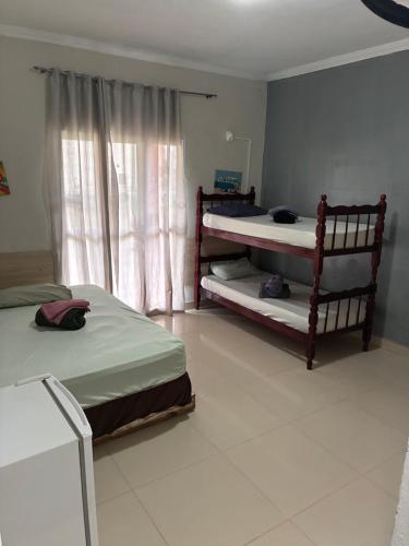 a bedroom with two bunk beds and a window at pousada ranchinho sorocaba in Sorocaba