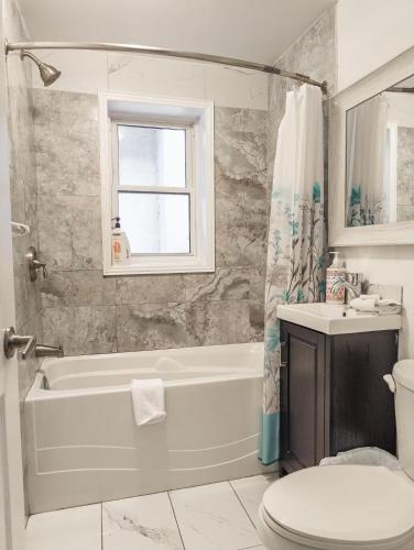 a bathroom with a tub and a toilet and a sink at Suitestay Apartments Hotel in Ottawa