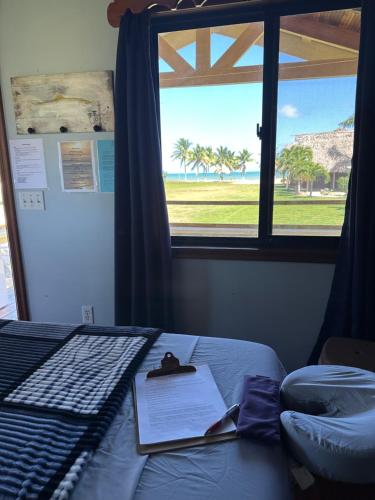 ダンリガにあるSunshine Cabanas At Ocean Viewの海の見える窓のあるベッドのある寝室