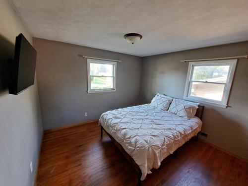 a small bedroom with a bed and two windows at Location! Large Home, Country Views, Entertainment in Dubuque