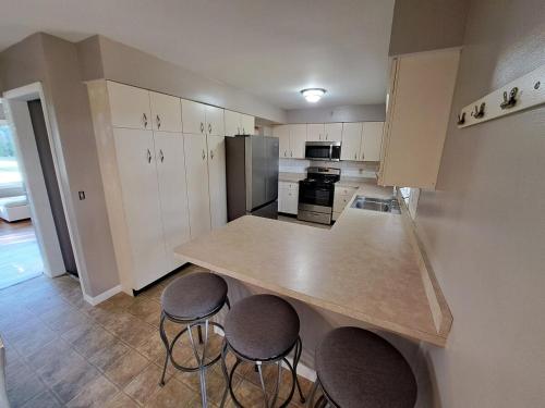 a kitchen with three bar stools and a counter top at Location! Large Home, Country Views, Entertainment in Dubuque