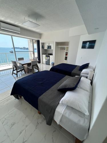 a large bedroom with a large bed and a table at Suite Frontal a Pie de Playa con Terraza Panorámica in Acapulco