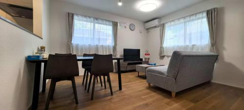 a living room with a dining room table and chairs at 新築江の電腰越駅前徒歩1分鎌倉江の島観光に最適鎌倉腰越駅前ｂ棟 in Kamakura