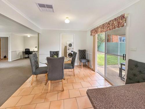 a living room with a table and chairs at Suburban Bliss - Elegant Villa 1 in Wagga Wagga