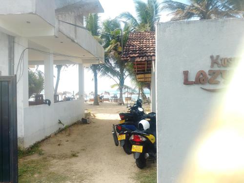 a motorcycle parked in front of a building at Kusuma's Lazy Left hostel in Midigama