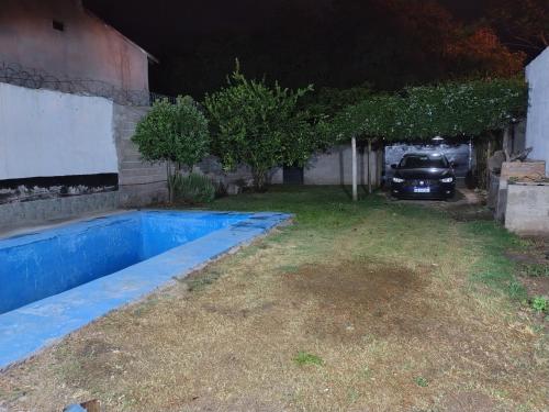 une voiture garée à côté d'une maison avec piscine dans l'établissement Casa en alquiler por día en La Rioja, à La Rioja