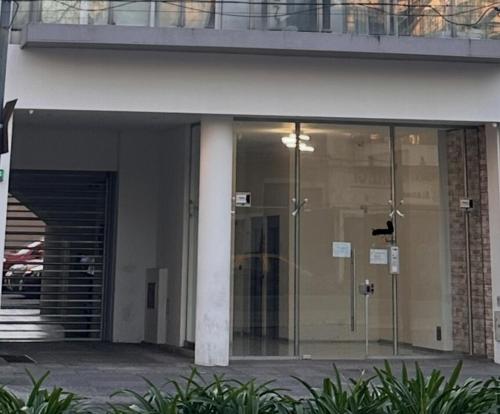 a glass entrance to a building with a revolving door at Stylish Modern apartment with automatic parking in Buenos Aires