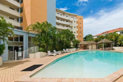 a swimming pool in front of a building at Broadwater view in southport 1b in Gold Coast