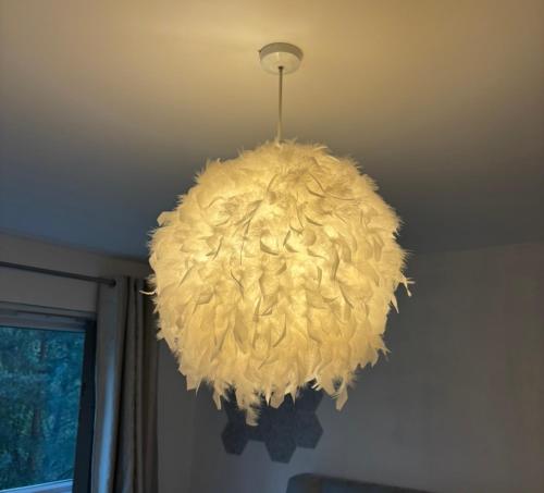 una gran lámpara de araña amarilla colgada del techo en Platt Bridge Contractor Stays-One Bedroom house, en Abram